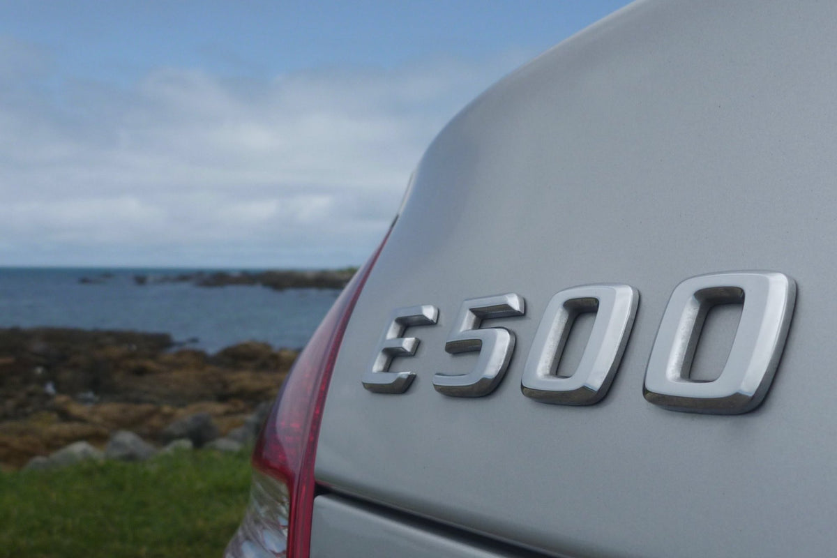 El emblema E500 en el maletero de un Mercedes plateado